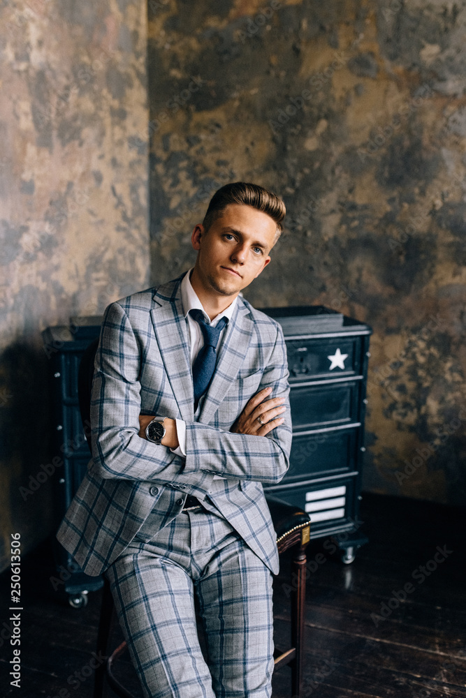 Naklejka premium A man in a blue suit is sitting on a chair