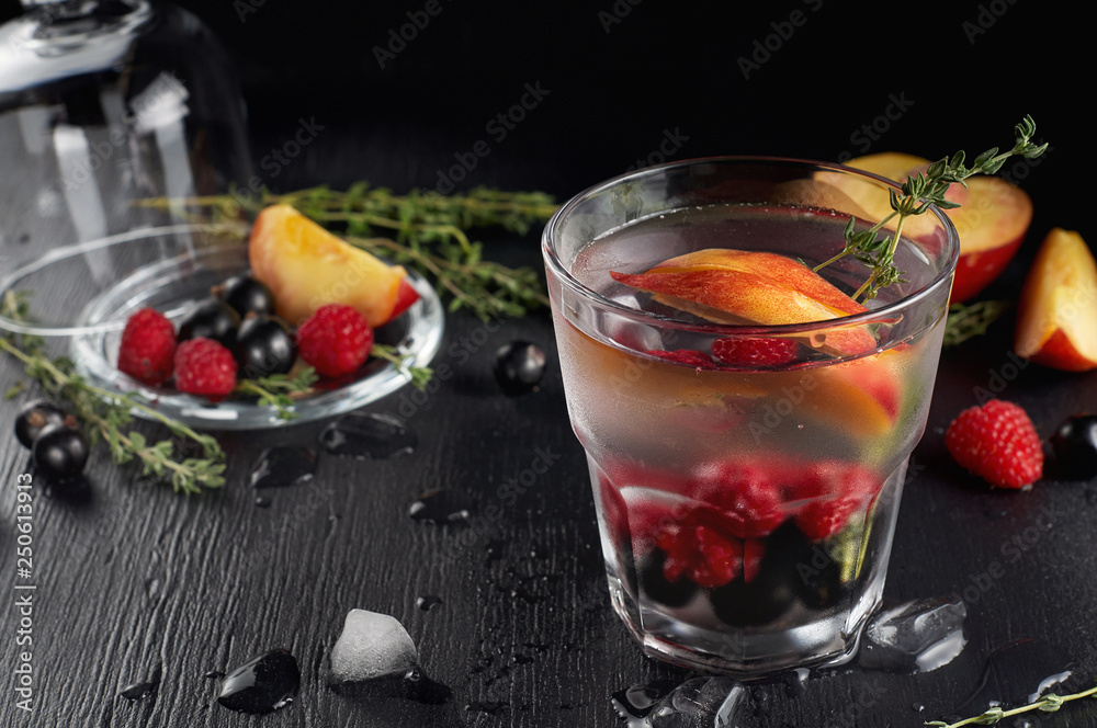 Raspberry thyme gin and tonic cocktail with blackcurrant and peaches Raspberry thyme gin and tonic cocktail with blackcurrant and peaches