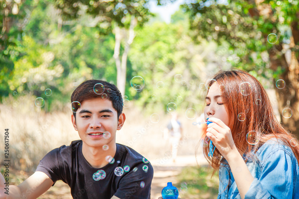 Young couple blowing soap bubbles and smiling. Beautiful & Happy family concept. Young couple blowing soap bubbles and smiling. Beautiful & Happy family concept.