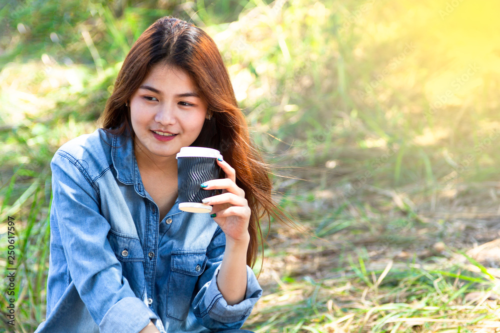 Young woman holding a take-away coffee outdoor.
