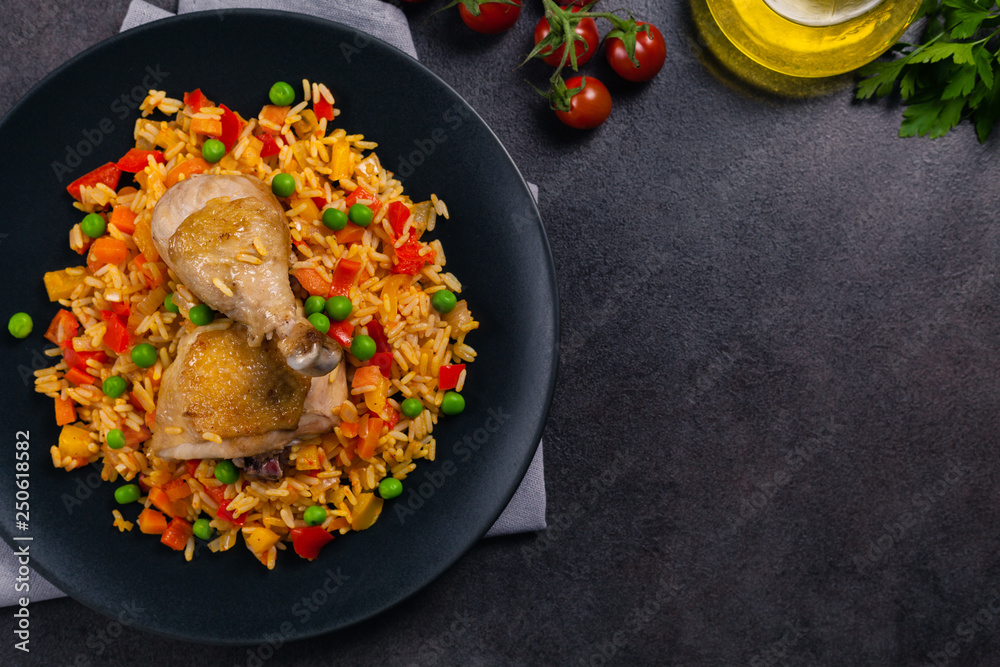 Arroz con pollo. Baked pieces of chicken with bone, rice with paprika and peas. - obrazy, fototapety, plakaty 