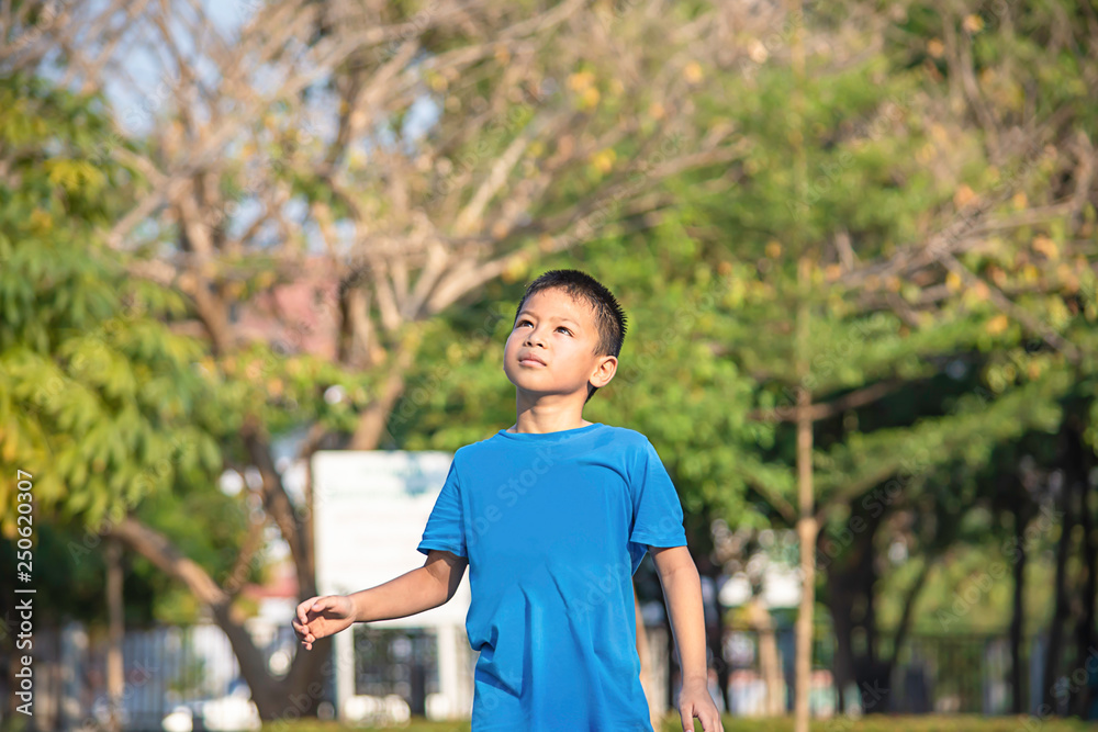Portrait of a boy Asia laughing and smiling happily Background blurry trees in park. Portrait of a boy Asia laughing and smiling happily Background blurry trees in park.