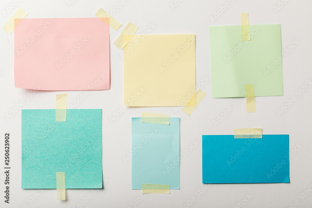 colorful blank papers with sticky tape on white background colorful blank papers with sticky tape on white background