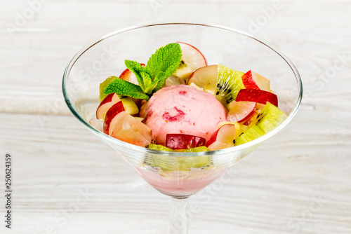 Ice cream in a glass cup with apples and kiwi