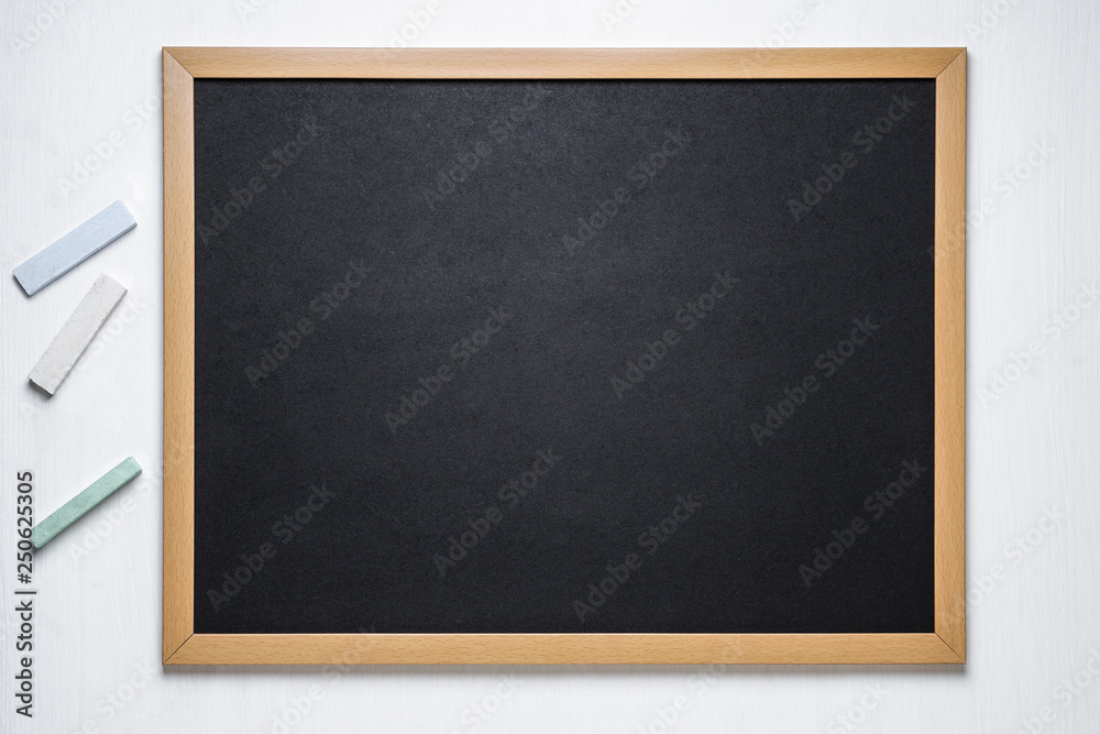black chalk board and several colored chalk on a white background black chalk board and several colored chalk on a white background