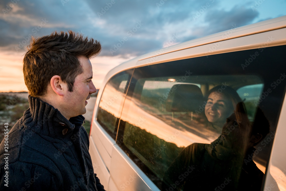 Couple looking at each other through the car window.Couple smiling and happy