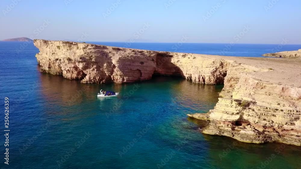 Aerial drone view video of beautiful volcanic caves of Xylobatis or Ksylobatis with deep blue waters, Koufonissi island, Cyclades, Greece Aerial drone view video of beautiful volcanic caves of Xylobatis or Ksylobatis with deep blue waters, Koufonissi island, Cyclades, Greece