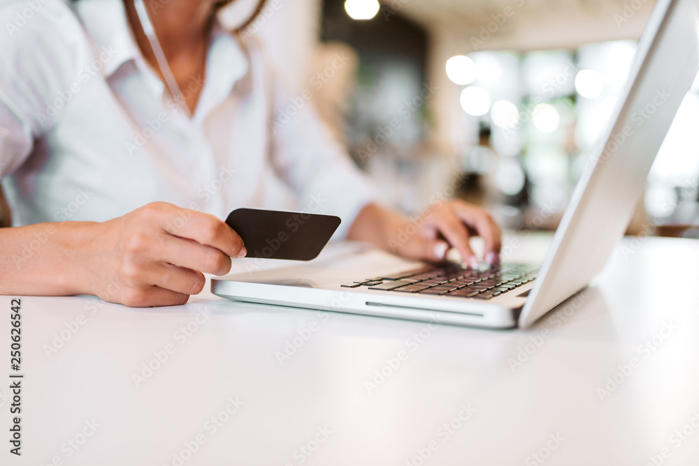 E-commerce concept. Using credit card and laptop for online shopping. Close-up. E-commerce concept. Using credit card and laptop for online shopping. Close-up.