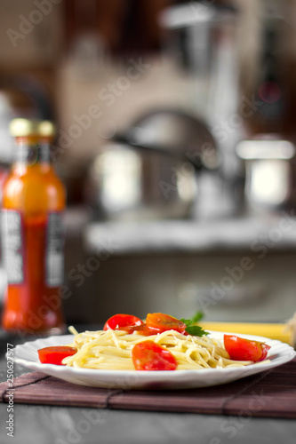 Spaghetti pasta in tomato sauce with cheese and parsley. Italian spaghetti pasta over dark stone background.