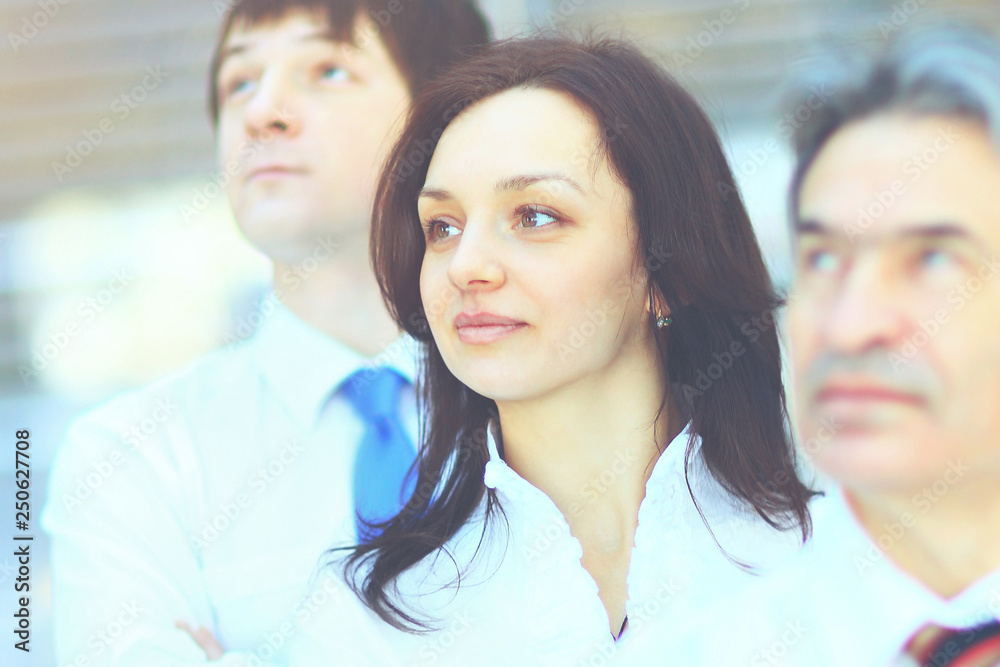 Successful business group in a row smiling and looking up Successful business group in a row smiling and looking up