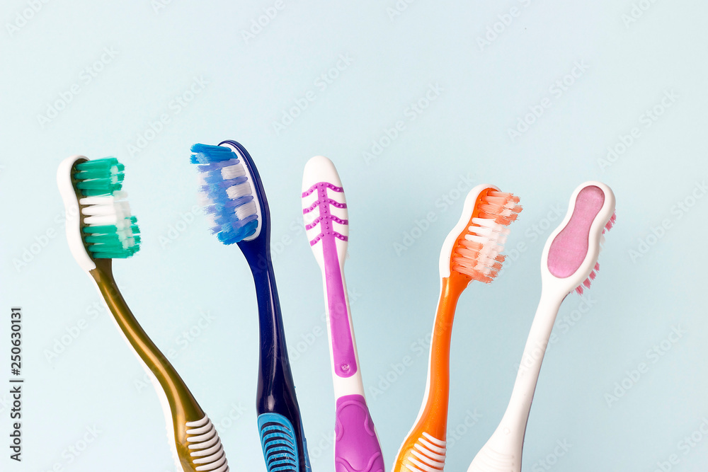 Multicolored toothbrushes on a blue background, copy space Multicolored toothbrushes on a blue background, copy space