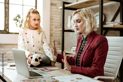 Serious resolute woman in red jacket showing insufferable gesture