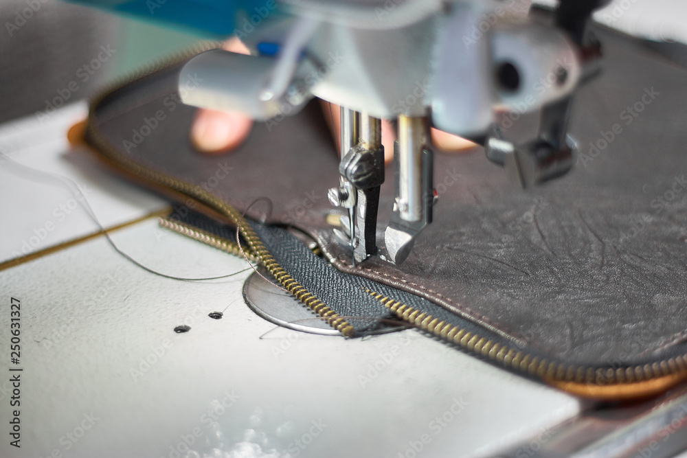 Designer stitching a fragment of a leather bag on the sewing machine  Stock-Foto | Adobe Stock