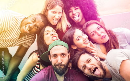 Multiracial millenial friends taking selfie with funny faces - Happy youth friendship concept against racism with international young trendy people having fun together - Psychedelic radial filter