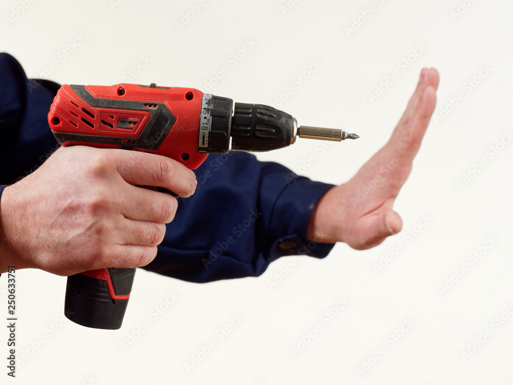 man in workwear holds a drill tool on white background. man in workwear holds a drill tool on white background.