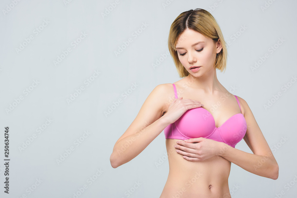 beautiful woman in pink bra touching breast isolated on grey, breast cancer  concept Stock Photo | Adobe Stock