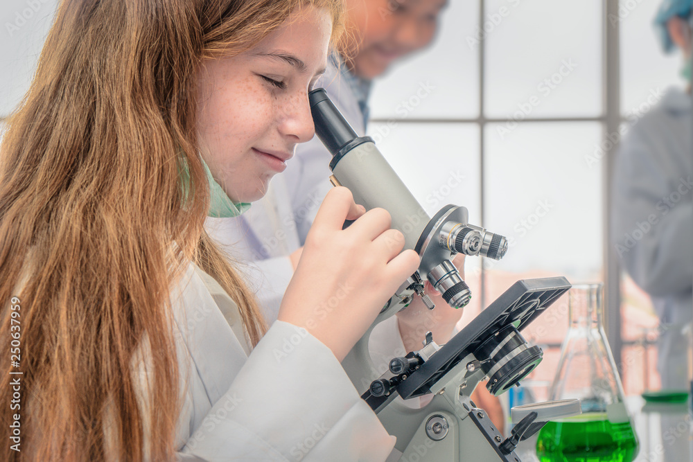 student using microscope in biology laboratory student using microscope in biology laboratory