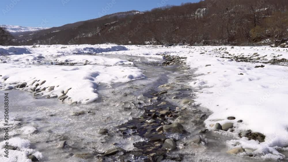 Frozen mountain river with crystal clear water