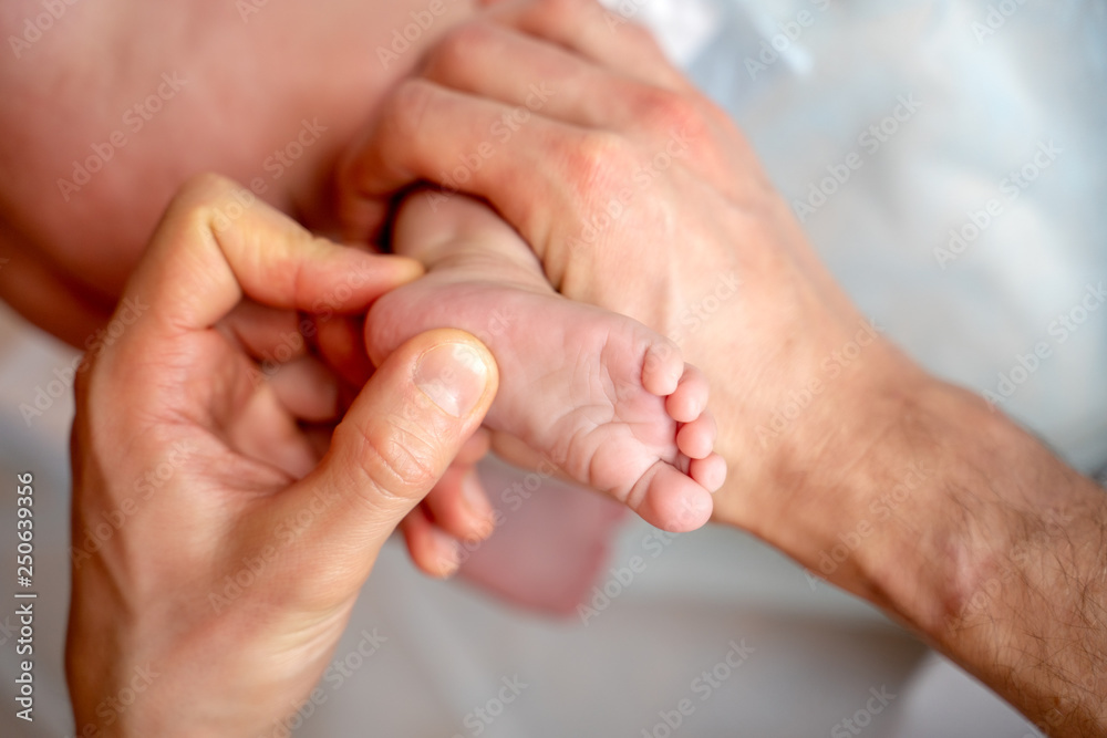 Photo from above of kid’s feet and hands of masseur. Photo from above of kid’s feet and hands of masseur.