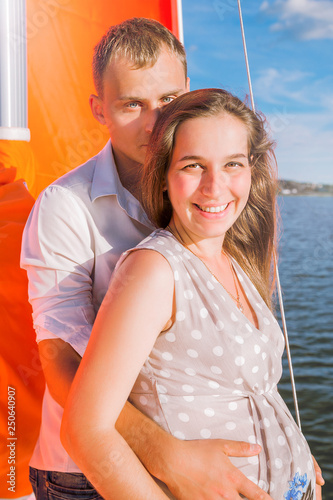 A happy family. Husband and pregnant wife on a yacht © ribalka yuli