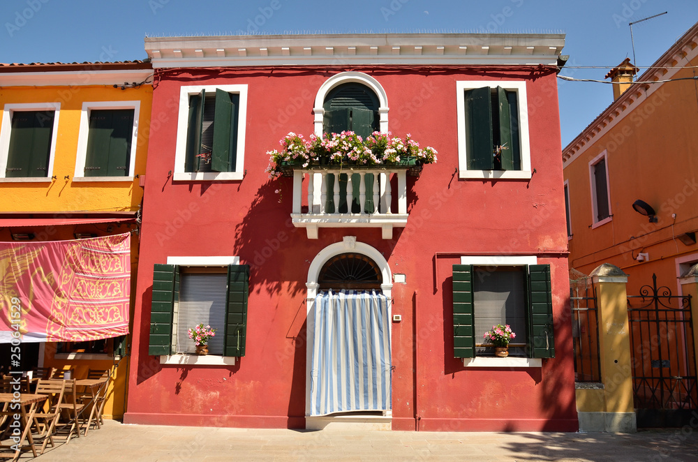 Mediterranean style. Window with green shutters and balcony on red wall. Burano island near Venice, Italy