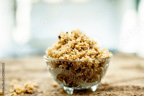 Close up of popular Indian & Asian sweet dish i.e. Malida or churma na ladu or moti chur na ladu in a bowl on brown surface.
