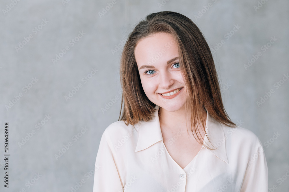 Smiling young woman portrait. Youth and beauty. Copy space on grey background. Smiling young woman portrait. Youth and beauty. Copy space on grey background.