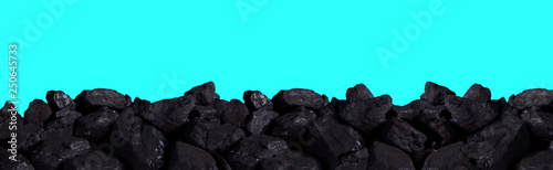 A pile of black coal on an isolated background of blue sky.