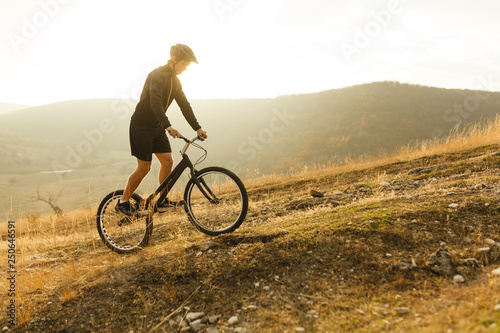 Sportsman standing on bike on hill © kegfire