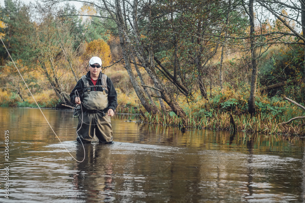 A fisherman fishing with fly fishing. A fisherman fishing with fly fishing.
