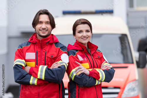 Smiling paramedics in uniform standing with crossed arms photo