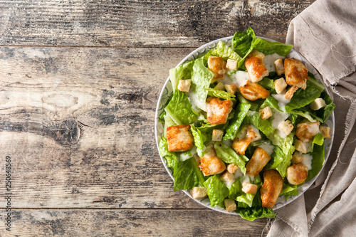 Quadro su tela Caesar salad with lettuce,chicken and croutons on wooden table