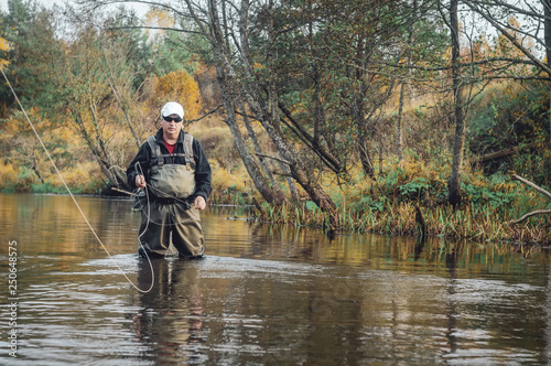 A fisherman fishing with fly fishing. © Виталий Волосевич