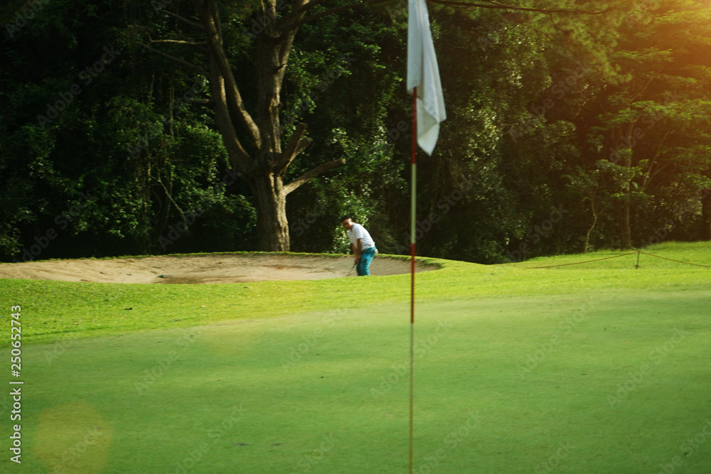 Obraz premium Golfers are putting golf in the evening golf course, on sun set evening time.