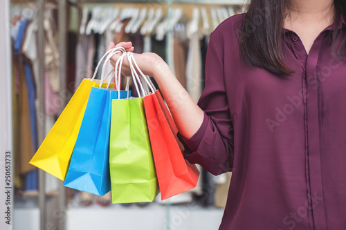 Consumerism, shopping lifestyle concept, Young woman standing and holding colorful shopping bags enjoying in shopping