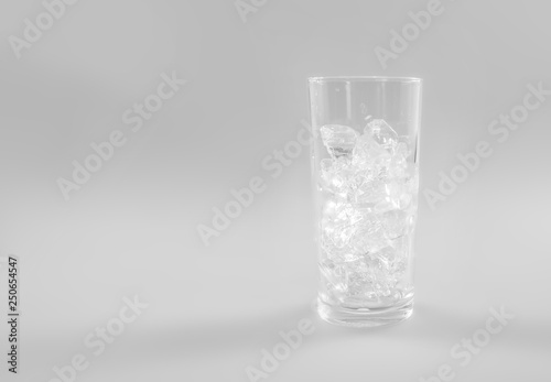 Ice cubes into glass on white background.