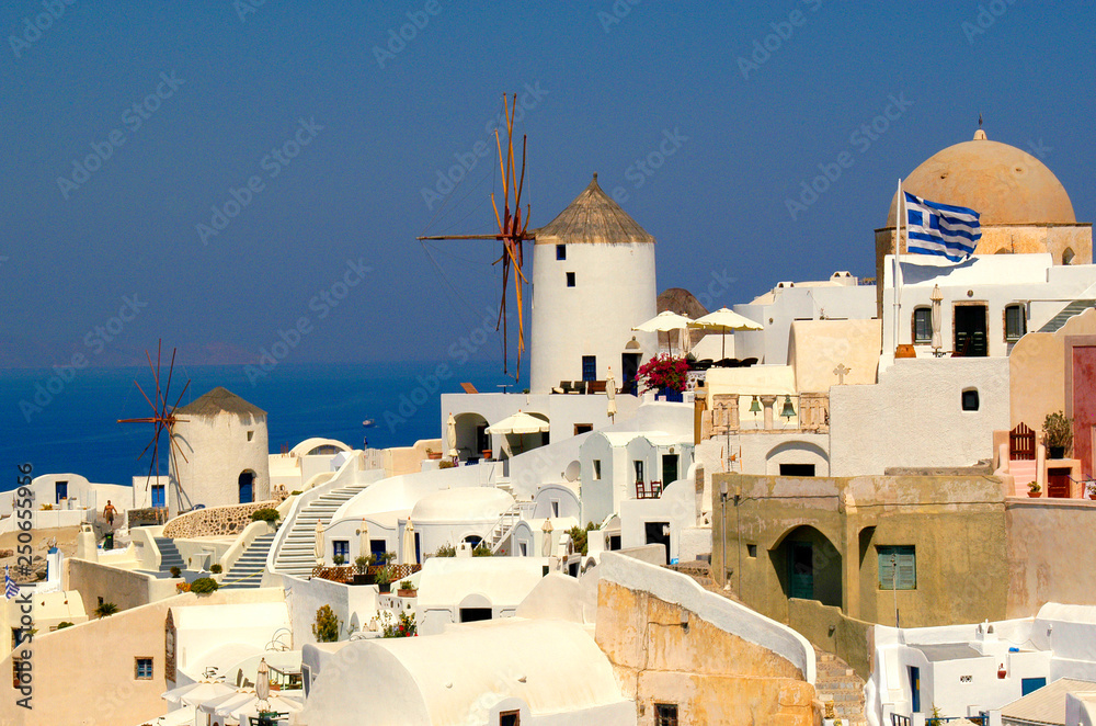 Greek windmill on the cliffs of Santorini with beautiful views of the blue Aegean. 
