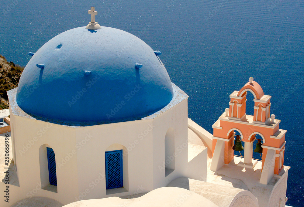 The island of Santorini offers breathtaking views over the ocean from colorful blue dome churches. 