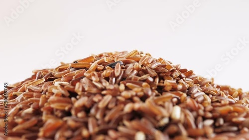 Brown rice rotating on white background. photo