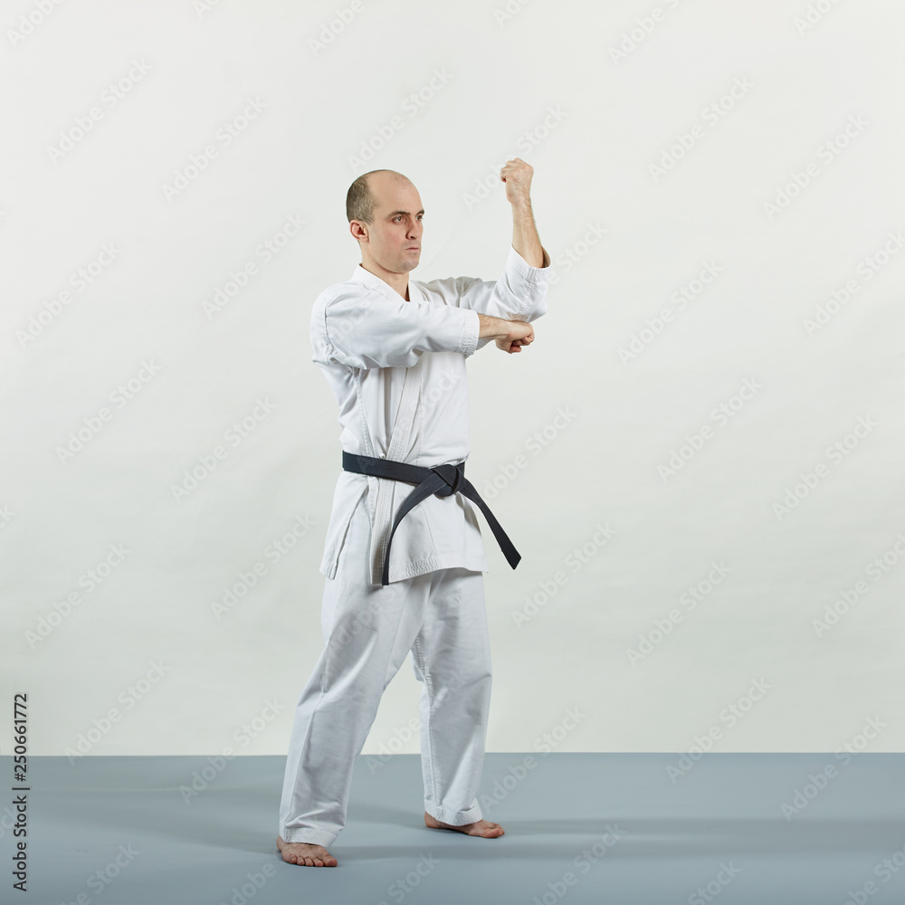 On a gray cover a black belt athlete trains formal exercises On a gray cover a black belt athlete trains formal exercises