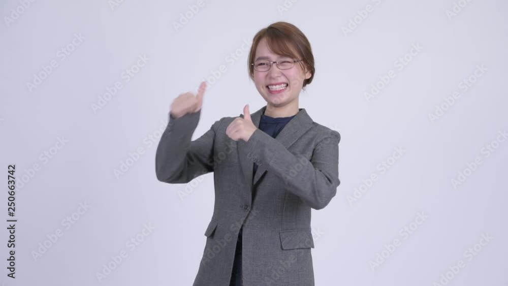 Young happy Asian businesswoman looking excited while giving thumbs up Young happy Asian businesswoman looking excited while giving thumbs up