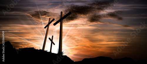 Obraz na plátne Three crosses on a dramatic sky at sunset