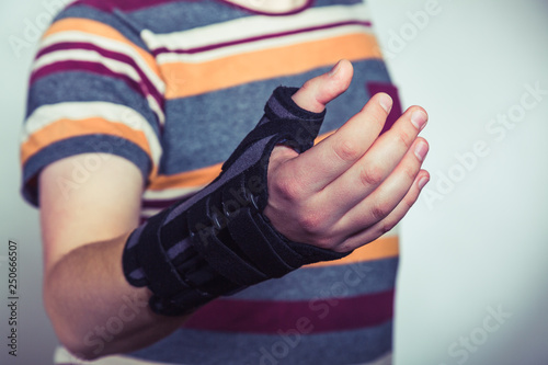 Man with hand in orthopedic black orthosis photo
