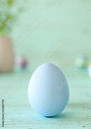 One Easter egg decorated on mint green wood table