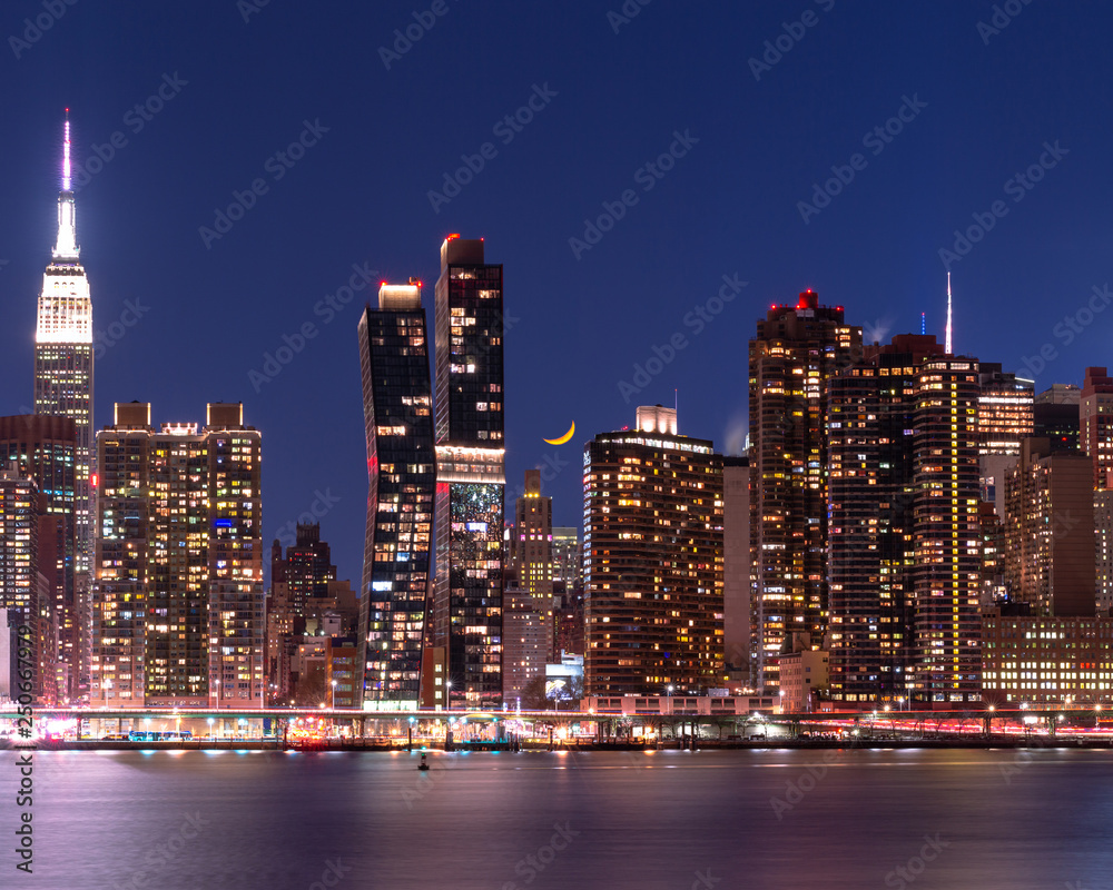 Obraz premium Midtown Manhattan with yellow moon in waxing phase at night with long exposure