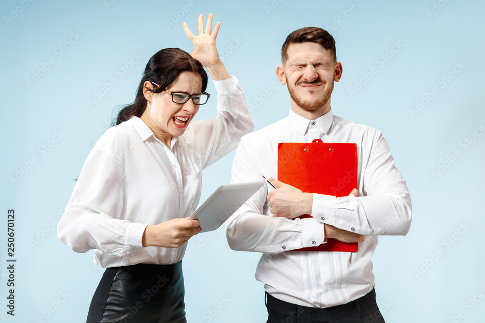 Angry boss. Woman and his secretary standing at office or studio. Businesswoman screaming to his colleague. Female and male caucasian models. Office relationships concept, Human emotions Angry boss. Woman and his secretary standing at office or studio. Businesswoman screaming to his colleague. Female and male caucasian models. Office relationships concept, Human emotions