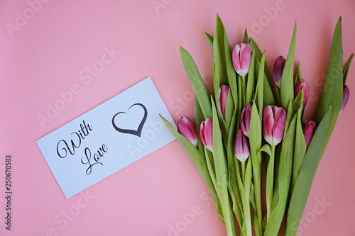 Styled feminine flatlay with pink tulip flowers and card WITH LOVE
