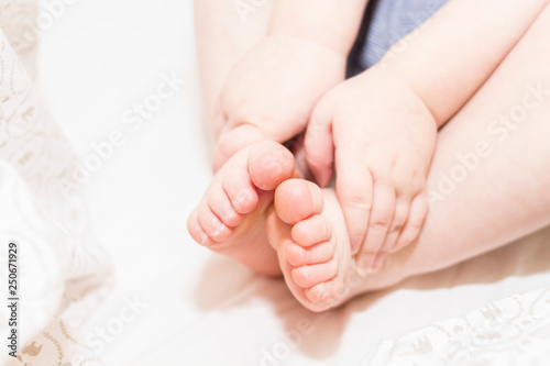 Baby feet and hands in the bed. Copy space. Place for text