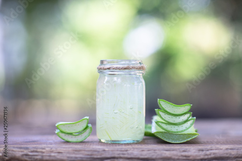 Fresh aloe vera plant, stem slices and gel on wooden background, skin therapy concept