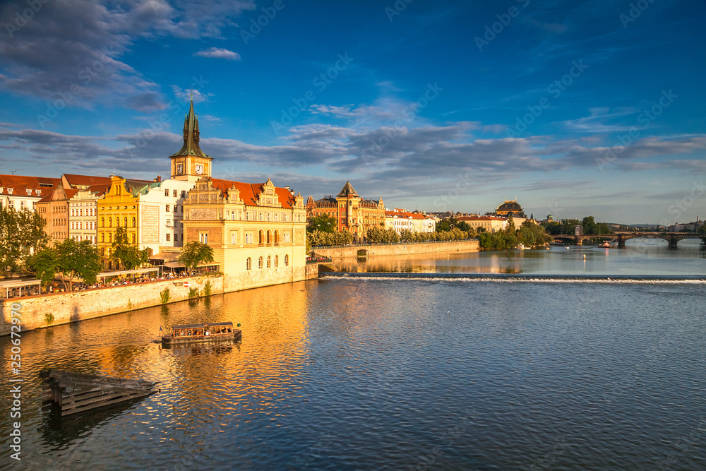 Vltava river and waterfront of the old town with the theater in Prague at sunset, Czech Republic, Europe.